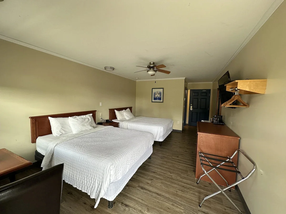 Guest room with two queen beds and a luggage rack